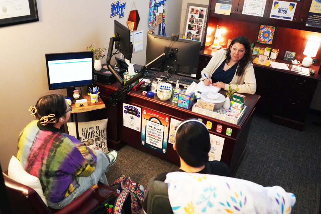 CLA Advisor meets with two students to discuss class schedule